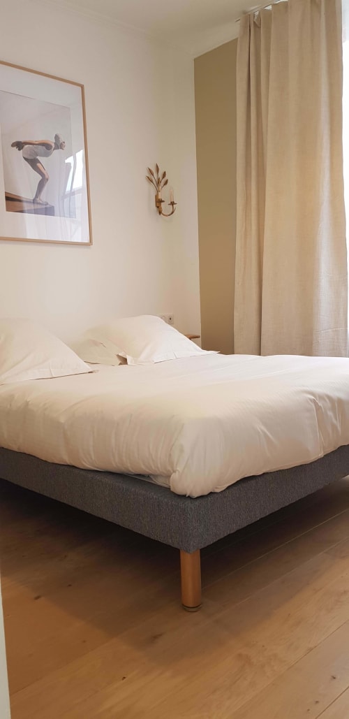 Chambre moderne à l'hôtel Les Cabines à Houlgate avec literie blanche, rideaux beige et décoration minimaliste