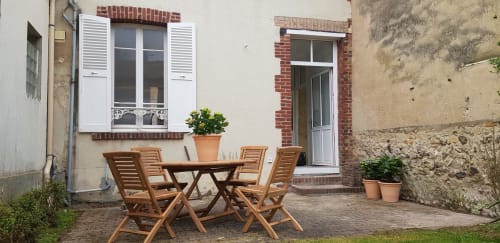 Terrasse de jardin charmante aux Cabines à Houlgate avec mobilier en bois et plantes en pots