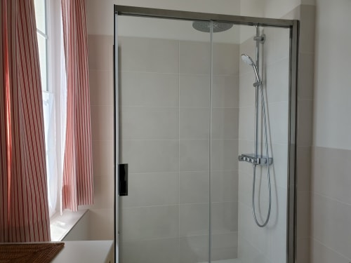 Douche moderne en verre avec pomme de douche pluie et douchette manuelle dans la chambre du Logis des Tourelles, Cognac
