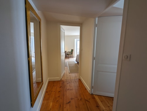 Couloir lumineux aux planchers en bois à Logis des Tourelles à Cognac, menant aux chambres d'hôtes