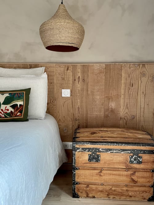 Double bed with wooden headboard and vintage trunk