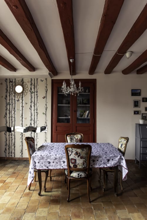 Salle à manger du Refuge des Alpes mancelles avec poutres apparentes, chaises en bois, nappe à motifs et mobilier d'époque
