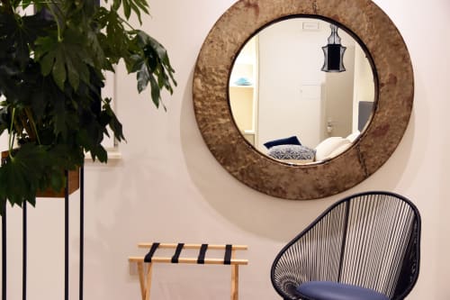 Camera moderna del B&B Dimora Vistamare a Barletta con specchio rotondo in sughero, sedia intrecciata nera e piante in vaso