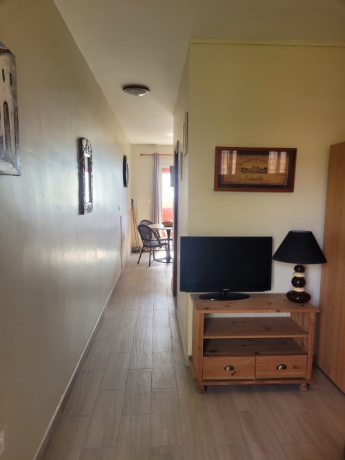 Couloir d'appartement corse avec meuble TV en bois, téléviseur écran plat et mobilier moderne