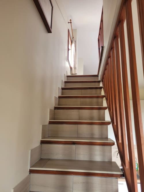 Escalier moderne aux rampes en bois et marches en bois clair dans un appartement de location de vacances en Corse