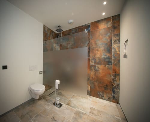Salle de bain moderne à la Villa Valtin avec douche ouverte, carrelage rustique, toilettes blanches et équipements contemporains au