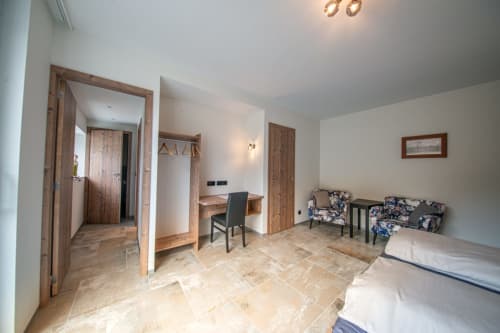 Spacieuse chambre à Villa Valtin avec lits jumeaux, bureau, coin détente et vue sur le jardin au Valtin
