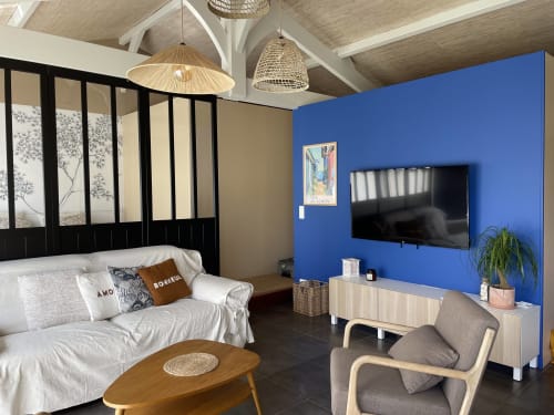 Chambre moderne à la Villa Eden Bleu, Biscarrosse avec mur d'accent bleu, TV, lit blanc, mobilier en bois et luminaires suspendus