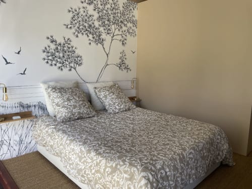 Chambre à la Villa Eden Bleu avec literie à motifs, fresque murale d'arbres et décor d'oiseaux volants à Biscarrosse