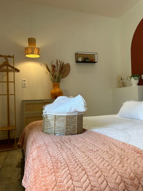 Chambre douillette à La Cour d'Hortense avec lits jumeaux, panier tissé, lampe suspendue et vue sur le jardin