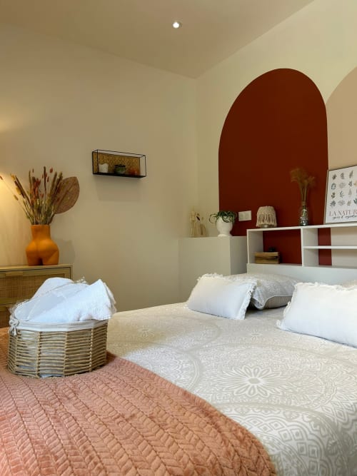 Chambre douillette à La Cour d'Hortense avec arche en terre cuite, literie crème et décor botanique