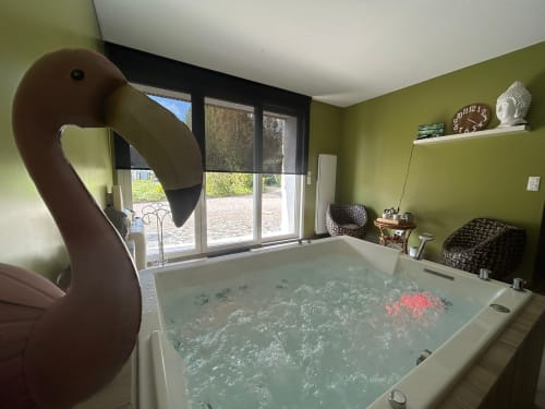 Baignoire de luxe avec eau bouillonnante et pétales de roses à La Cour d'Hortense, chambre d'hôtes à Sailly-Flibeaucourt, France