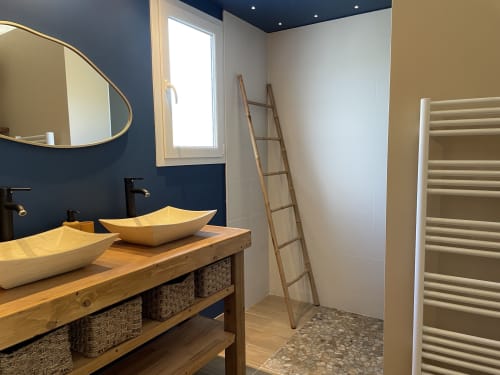 Salle de bains moderne de la Villa Eden Bleu avec vasques en bois, murs bleu marine et sèche-serviettes à Biscarrosse