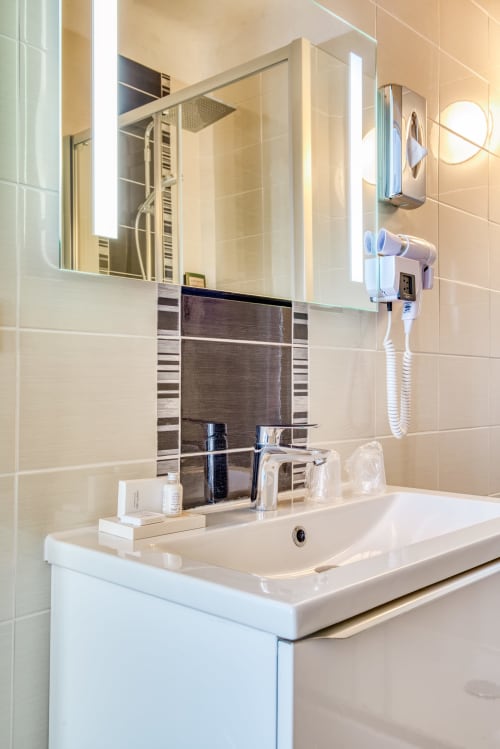 salle de bains avec produits d'accueil et sèche-cheveux