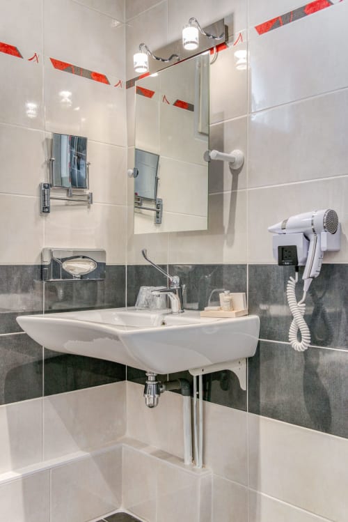 salle de bains avec sèche-cheveux et produits d'accueil