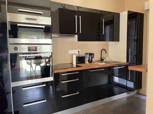 Cuisine moderne noire avec plan de travail en bois à la Villa Eden Bleu, Biscarrosse