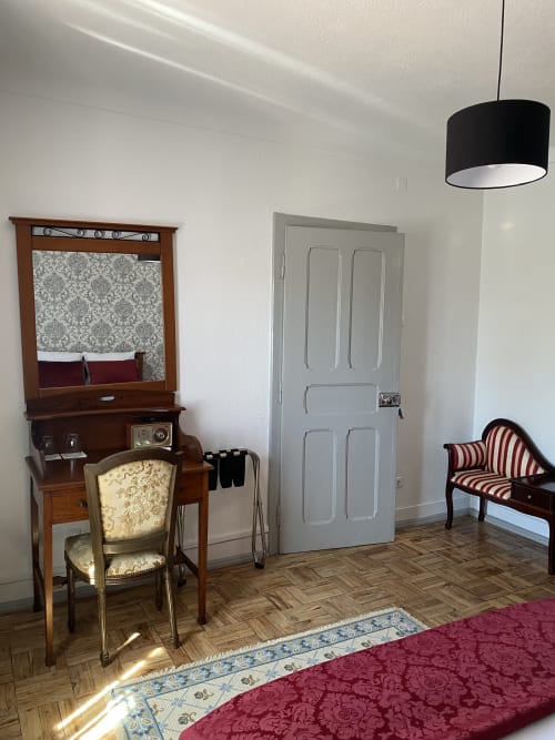 Vintage bedroom at Patio Da Villa guesthouse in Coruche with wooden vanity, period furniture, and burgundy accents