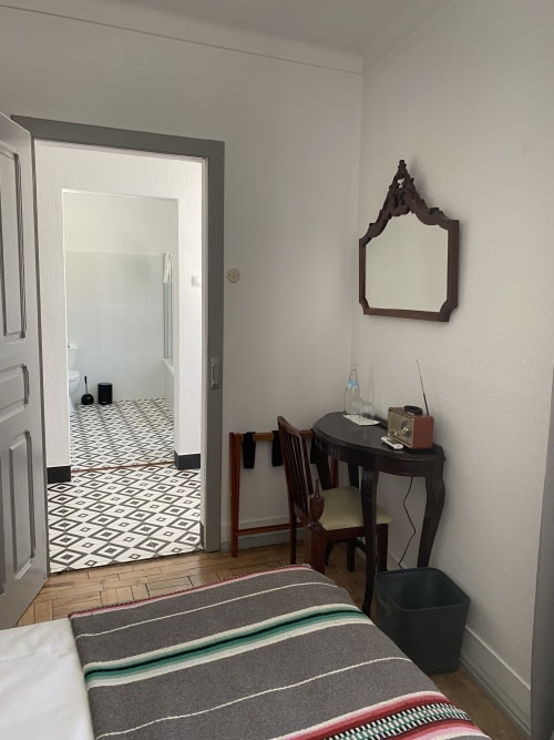 Bedroom at Patio Da Villa guesthouse in Coruche with striped bedding, desk, and bathroom access