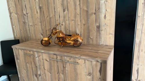 Sculpture décorative de motocyclette en bois sur commode en bois dans la chambre d'hôtes de la Villa Valtin