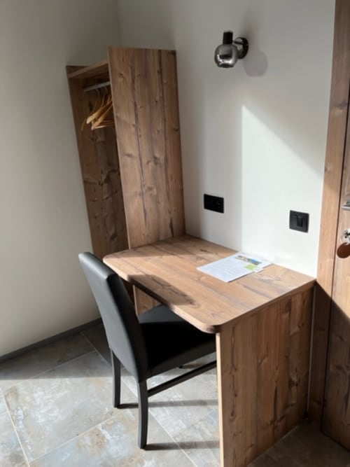 Bureau en bois moderne avec chaise noire dans la chambre Villa Valtin, vue montagne hébergement Valtin