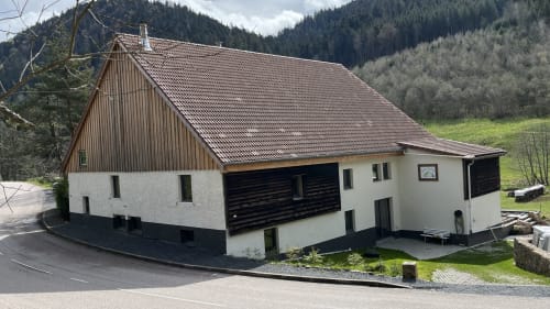 Villa Valtin, gîte en montagne au Valtin, France - Chalet moderne aux murs blancs et toit brun, immerge dans une vallée alpine boisée