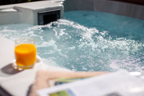 Cornish Holiday - Bodannon, a lovely close up of the bubbling Hot Tub with a glass of orange juice on the side.