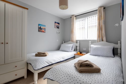 Cornish Holiday - 100 Hengar Manor. Downstairs twin bedroom with single beds, wardrobe with drawers, bedside cabinet, reading lights and complimentary towels.