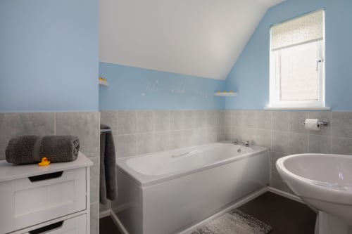 Cornish Holiday - 100 Hengar Manor.  Family Bathroom with bath, WC and pedestal hand basin. Storage unit, cabinet with mirror and heated towel rail.