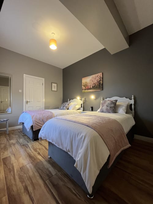 Room 5 at Steeple View B&B in Donegal featuring two twin beds with white linens, grey walls, and modern ceiling details.