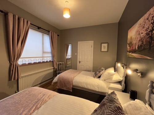 Room 5 at Steeple View B&B in Donegal with twin beds, ensuite bathroom, window view, and warm lighting