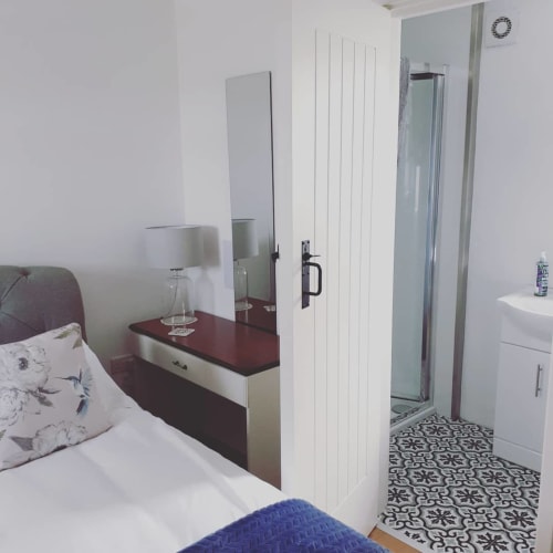 Bedroom en-suite at Ballymultimber Cottages barn cottage in Limavady with shower and vanity mirror