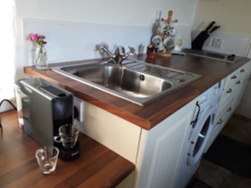 Modern kitchen sink and countertop in Cissy's Cottage at Ballymultimber Cottages, Limavady, with wooden countertop and white