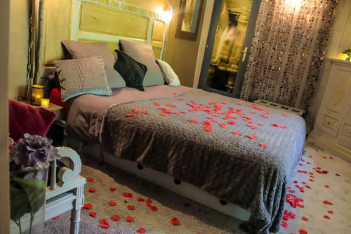 Lit pour couple, rempli de pétales de roses pour un moment romantique près de Lyon