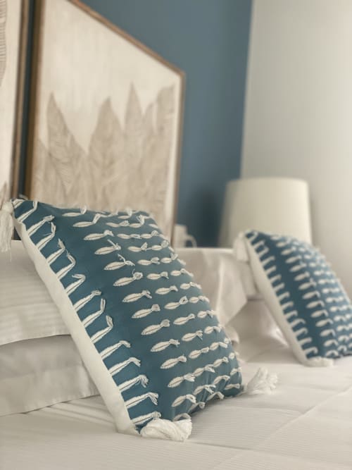 Dekorative blau-cremefarbene Kissen mit Fischmuster auf dem Bett des Verdolivo B&B in Sale Marasino