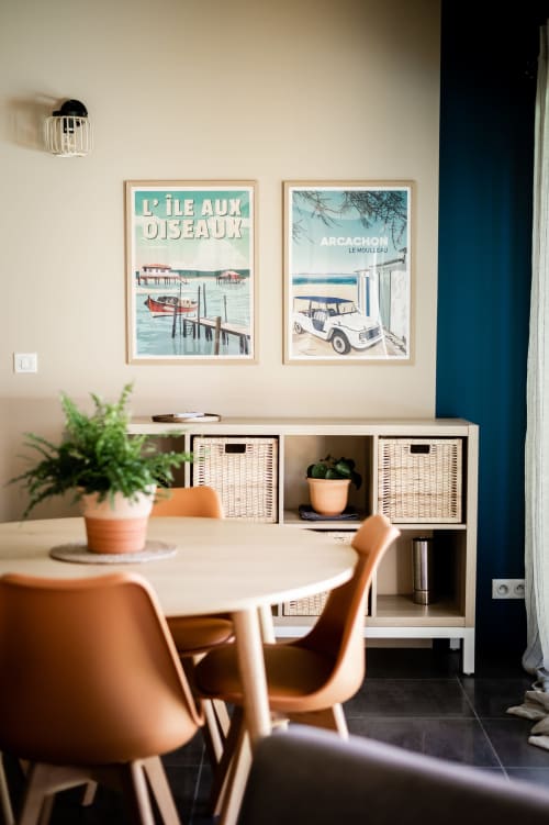 Villa Eden Bleu dining area with vintage travel posters, round table, terracotta chairs, and storage unit in Biscarrosse