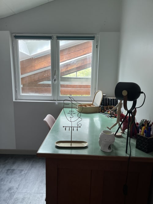 Modern villa workspace at La Conciergerie De Franck with mint green desk, artistic wire sculpture, black desk lamp, and pool