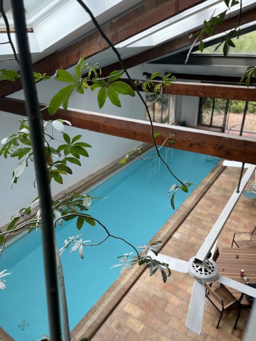 Lush climbing plants frame turquoise pool at La Conciergerie De Franck villa in Boissieres, France
