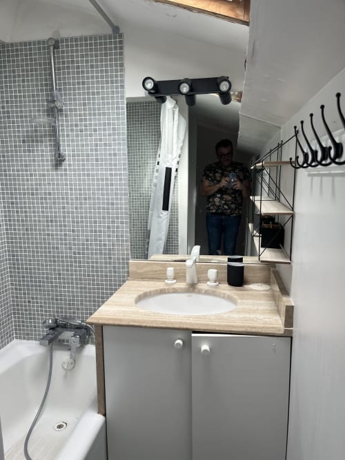 Modern bathroom at La Conciergerie De Franck villa in Boissieres with vanity, mirror, bathtub, and shower