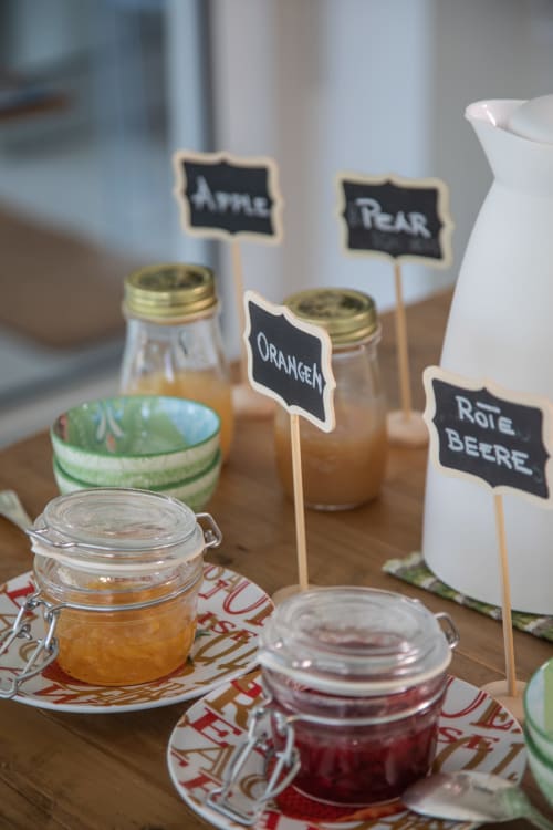 Homemade jam display at Verdolivo B&B with labeled jars of apple, pear, orange, and red berries preserves