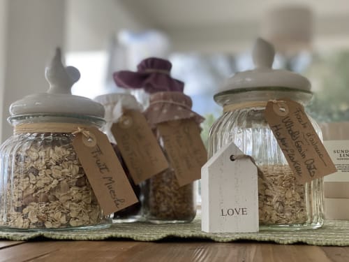 Glass storage jars with oats and dried goods labeled with tags at Verdolivo B&B in Sale Marasino, Italy