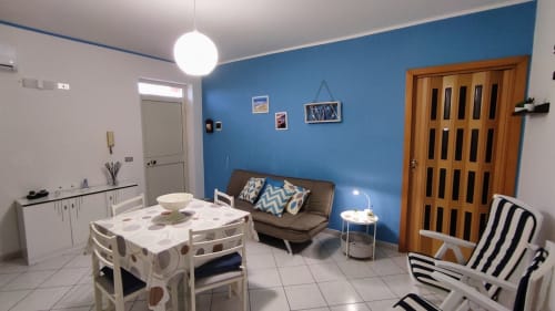 Soggiorno Stella Marina con parete accent blu, arredamento moderno e angolo cottura a Porto Empedocle, Agrigento