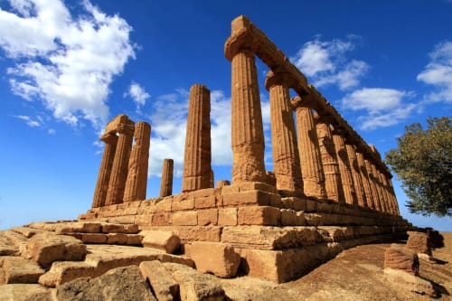 Rovine dell'antico tempio greco con colonne dorate sotto cielo azzurro, vicino all'hotel Stella Marina ad Agrigento, Sicilia