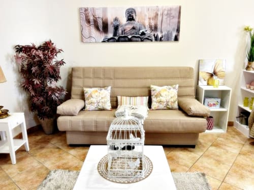 Sala de estar tipo loft Peperete en Baiona con sofá beige, jaula blanca decorativa y arte Buda
