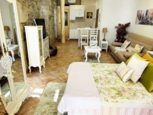 Luminoso loft apartamento en Baiona con cama, mesa de comedor, cocina, sofá, suelos de madera y mobiliario moderno