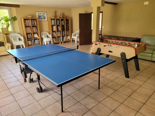 Salle de jeux avec bandes dessinées, table de ping-pong et baby-foot