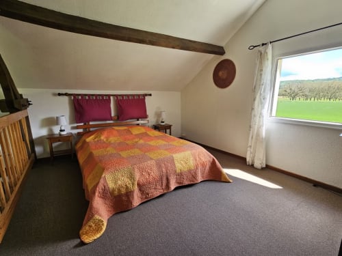 Chambre en mezzanine avec lit double et vue sur jardin
