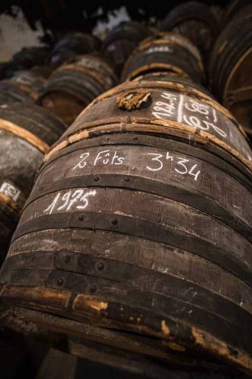 Fûts de chêne avec dates manuscrites dans la cave à cognac du Logis des Tourelles