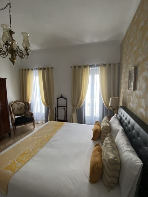 Elegante Quarto Superior King no Patio Da Villa com cortinas creme, lustre ornamentado e roupa de cama branca na pousada de Coruche