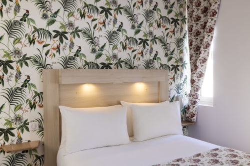 Chambre double standard à l'Hôtel De Lion Sur Mer avec papier peint botanique, tête de lit en bois avec éclairage intégré, blanc