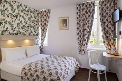 Chambre double standard de l'Hôtel De Lion Sur Mer avec parure florale, papier peint botanique et vue sur Lion sur Mer